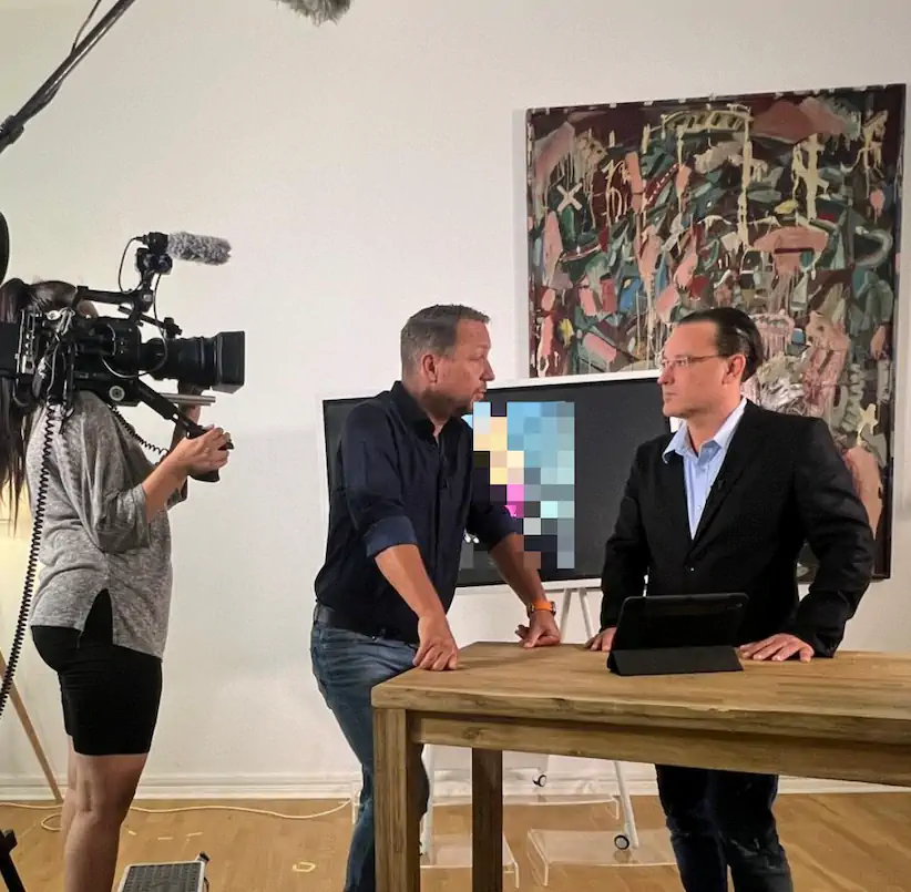 Eine Kamerafrau filmt ein Experteninterview mit einem Moderator und Rechtsanwalt Imanuel Schulz im RTL-Studio über das Löschen von Google Bewertungen und Reputationsschutz.
